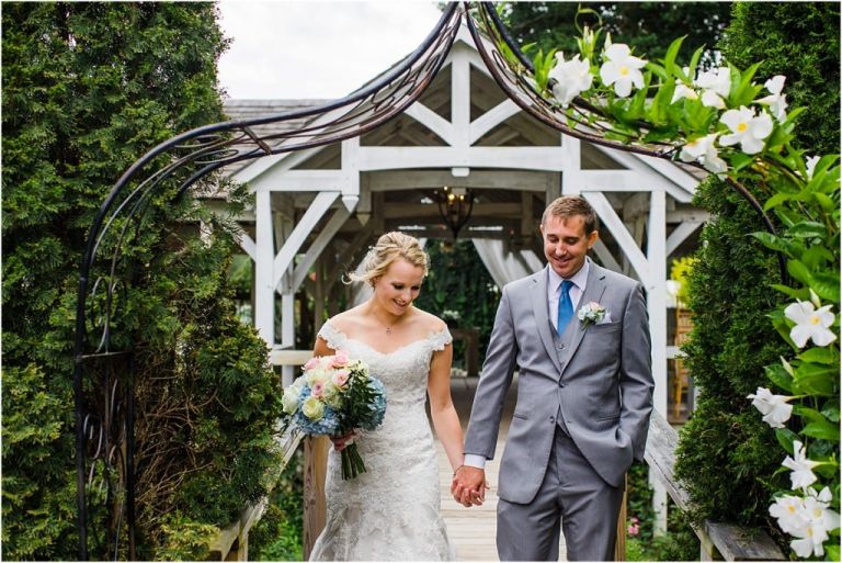 NJ wedding Photographer captures bride and groom walking on bridge at Abble Holmes Estate wedding