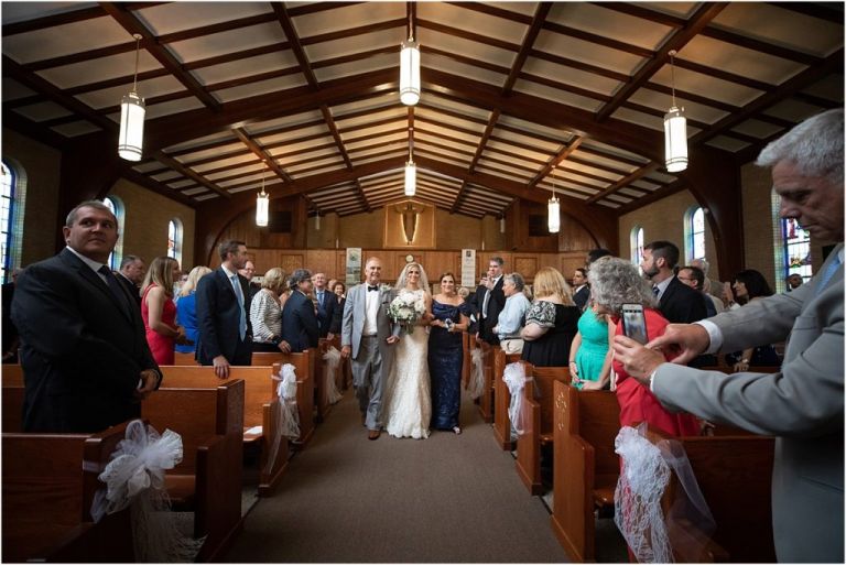 Bride walking down aisle with mom and dad in NJ church