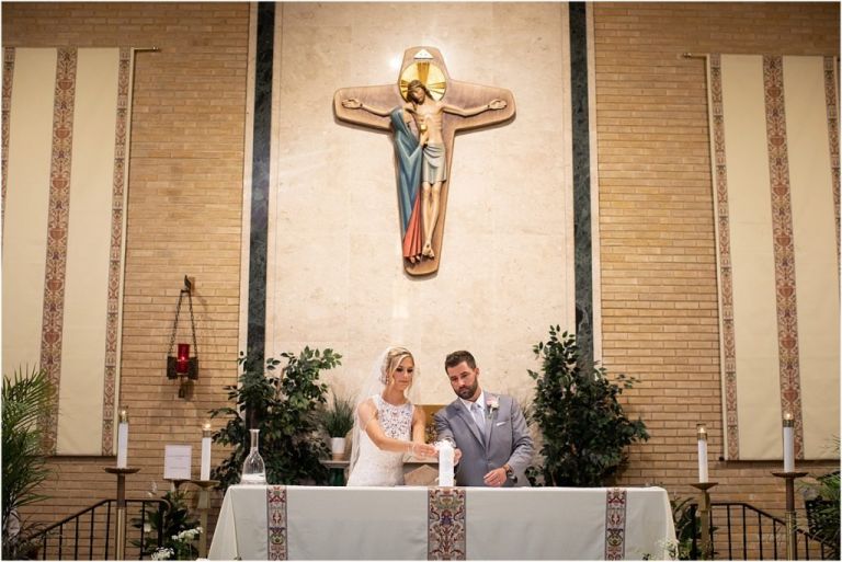 Bride and groom lighting candle during their NJ wedding ceremony