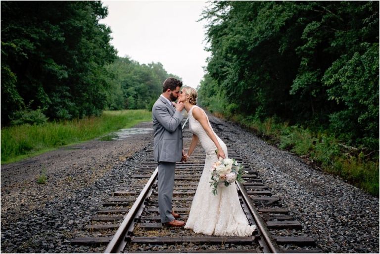 Bride and Groom kissing on railroad tracks at Everly at Railroad Wedding