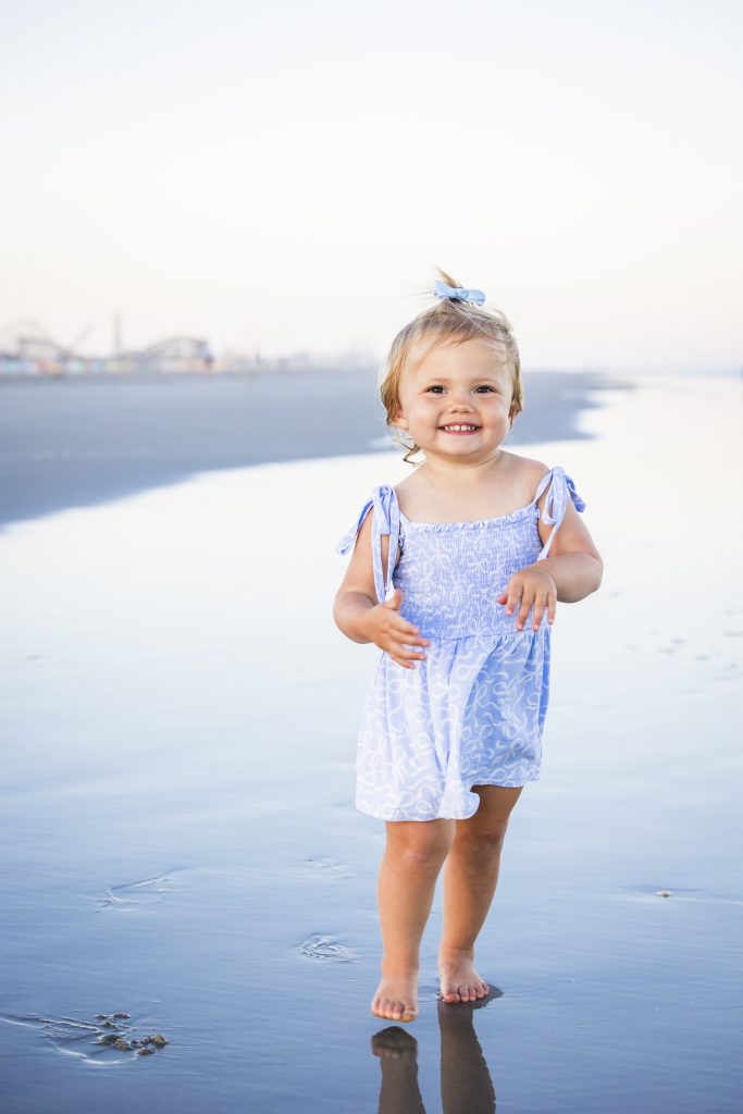 little girl being photographed on the beach