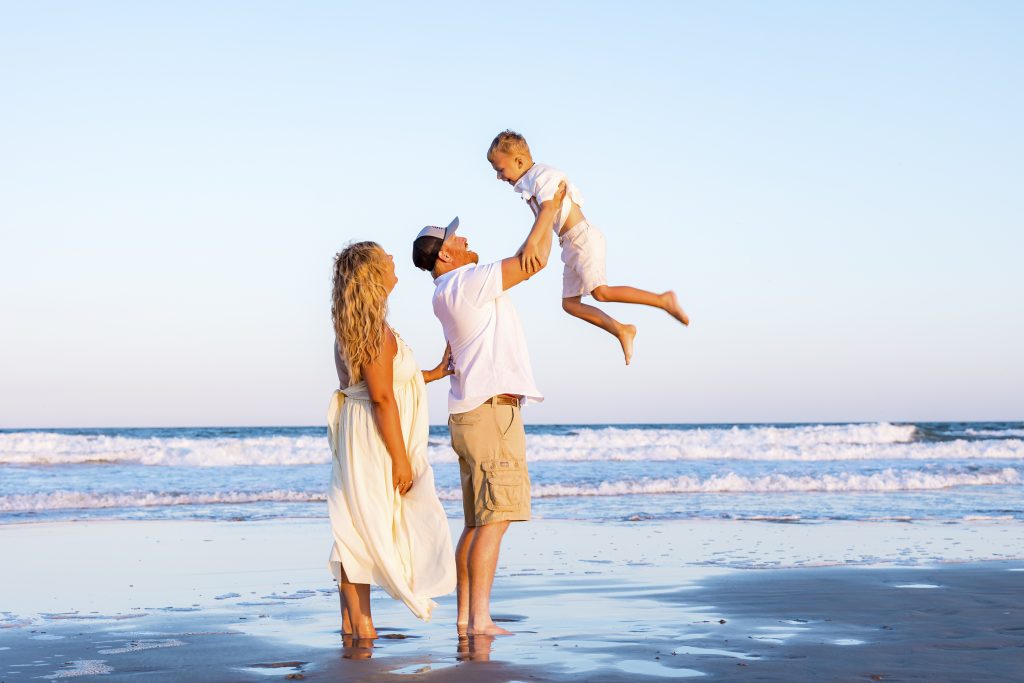 dad holding child on the beach