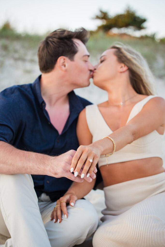 couple kissing after proposal on the beach
